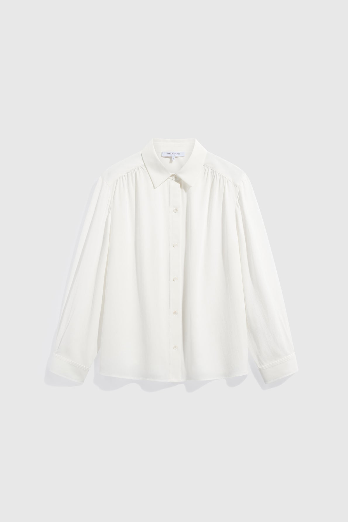 A long-sleeved, button-up chemise femme blanche with a collar, displayed against a plain light grey background.