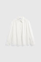 A long-sleeved, button-up chemise femme blanche with a collar, displayed against a plain light grey background.