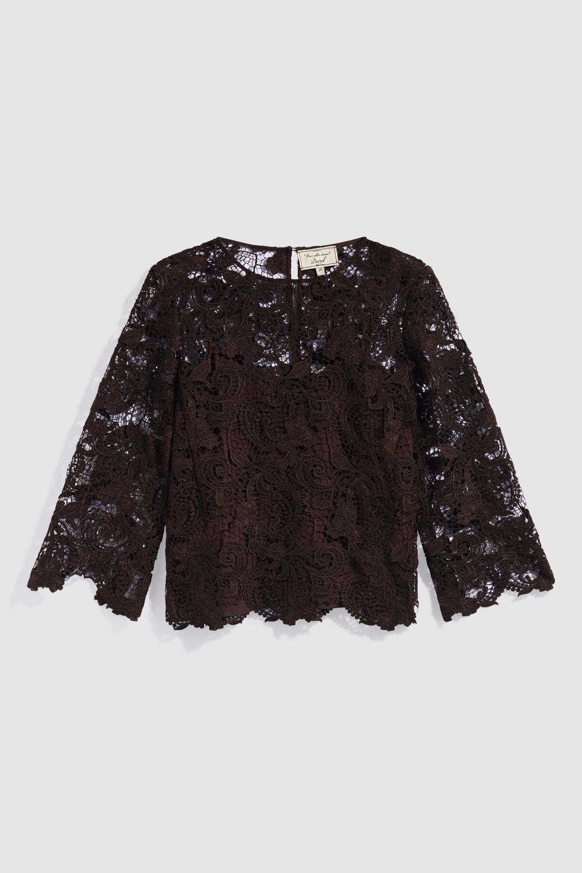 A long-sleeve, dark brown top dentelle blouse with a round neckline and scalloped edges, featuring an elegant motif fleuri design, laid flat on a light gray background.
