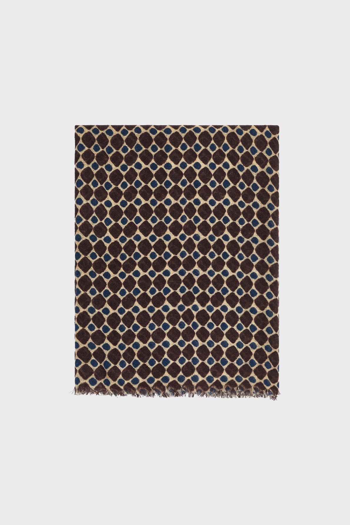 A patterned brown and beige square fabric with a grid of diamond shapes and small blue accents, featuring short fringe on one edge, displayed on a plain white background. This echarpe fine in laine et soie showcases an élégant imprimé géométrique that adds subtle sophistication to any look.