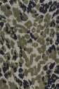 Close-up of fabric with a green, black, and beige camouflage pattern, resembling animal print with irregular, organic spots and shapes—perfect for an écharpe léopard crafted in soft laine cachemire featuring un élégant imprimé kaki.