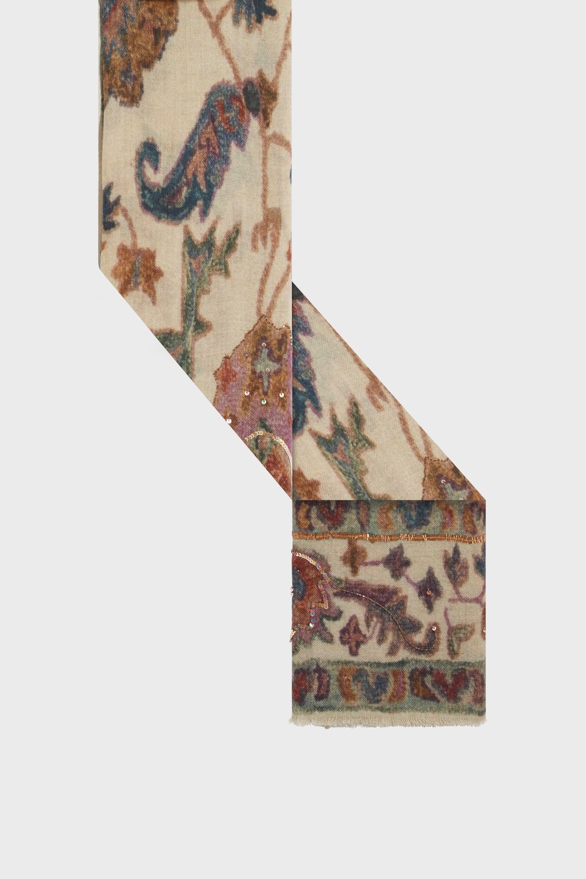 A beige textile featuring a motif cachemire and floral design in blue, brown, and purple, arranged in an L-shape against a plain background.