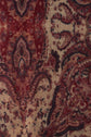 Close-up of a richly patterned fabric with red, tan, and black ornate paisley and floral designs, giving a vintage, decorative appearance—perfect for an élégante écharpe cachemire or an exquisite écharpe laine modal.