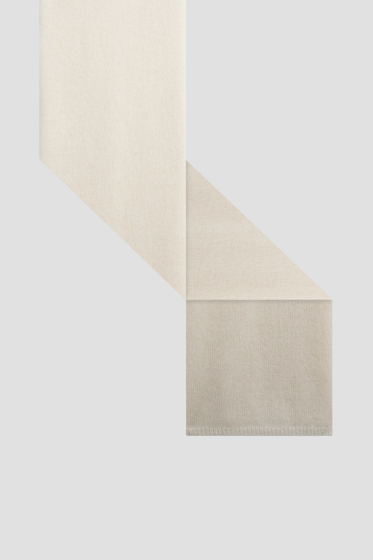 A beige fabric strip, reminiscent of a fine écharpe cachemire, is folded at a right angle on a light gray background, with clean edges and a smooth texture.