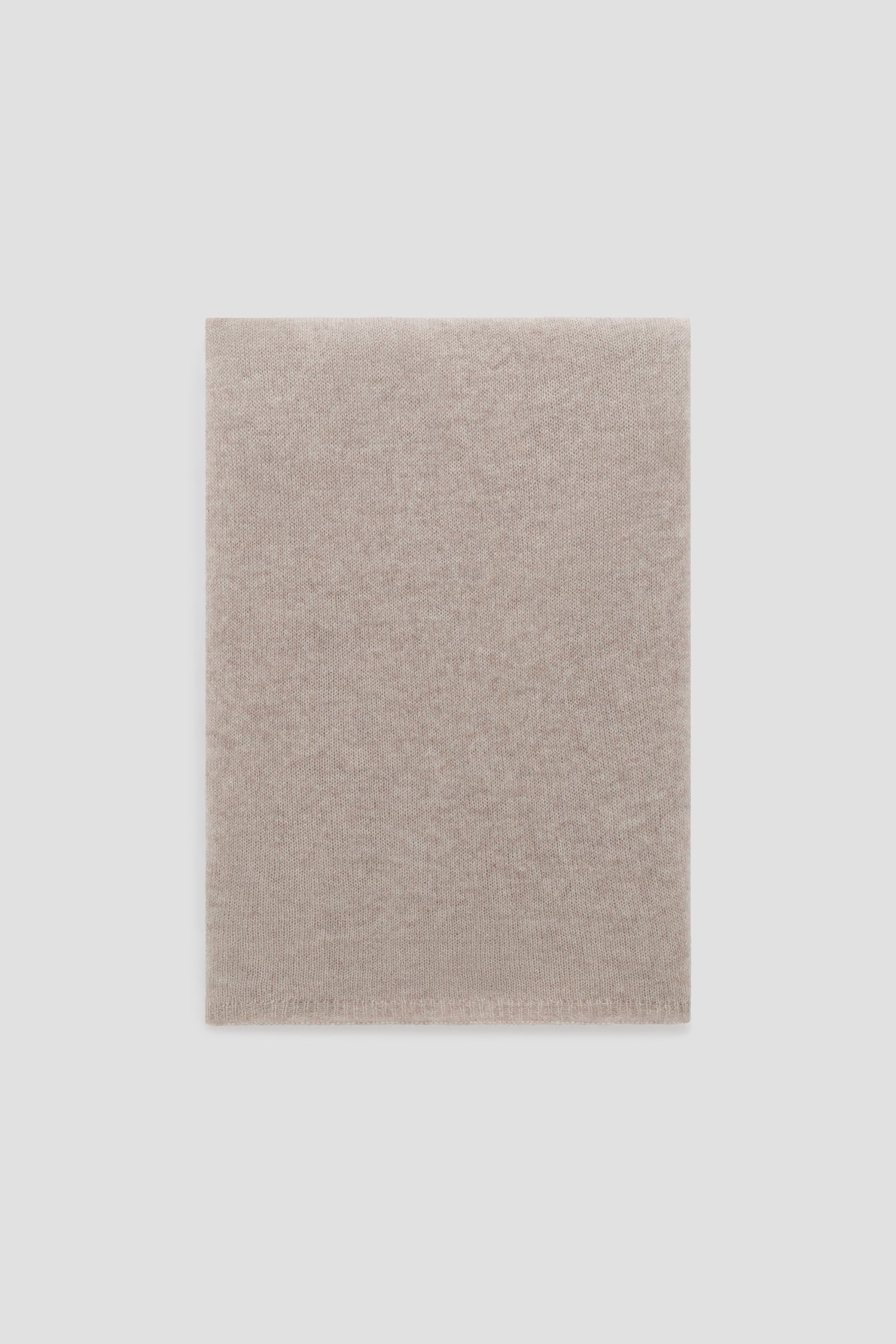 A neatly folded, light beige knit fabric écharpe displayed on a plain white background, exuding the timeless elegance of cachemire.
