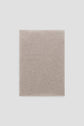 A neatly folded, light beige knit fabric écharpe displayed on a plain white background, exuding the timeless elegance of cachemire.