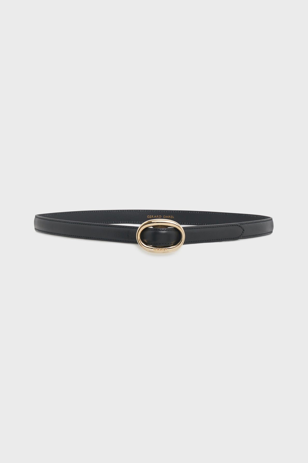 A slim black leather belt with white stitching and an oval gold buckle, the ceinture Sofia is a timeless accessoire de mode for every wardrobe, displayed elegantly on a plain white background.