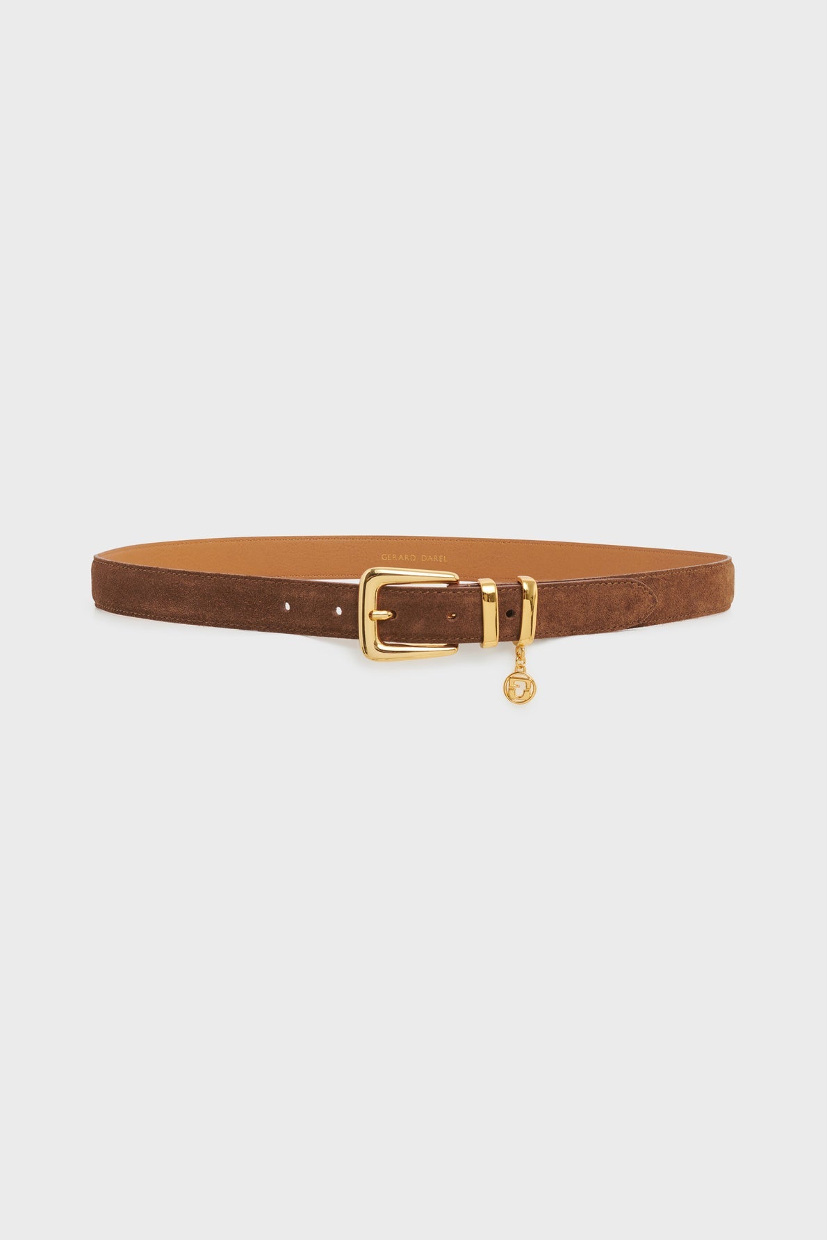 Brown suede ceinture élégante by Gerard Darel, featuring a gold boucle raffinée with a rectangular buckle and a small round gold charm hanging from the buckle, displayed on a plain white background.