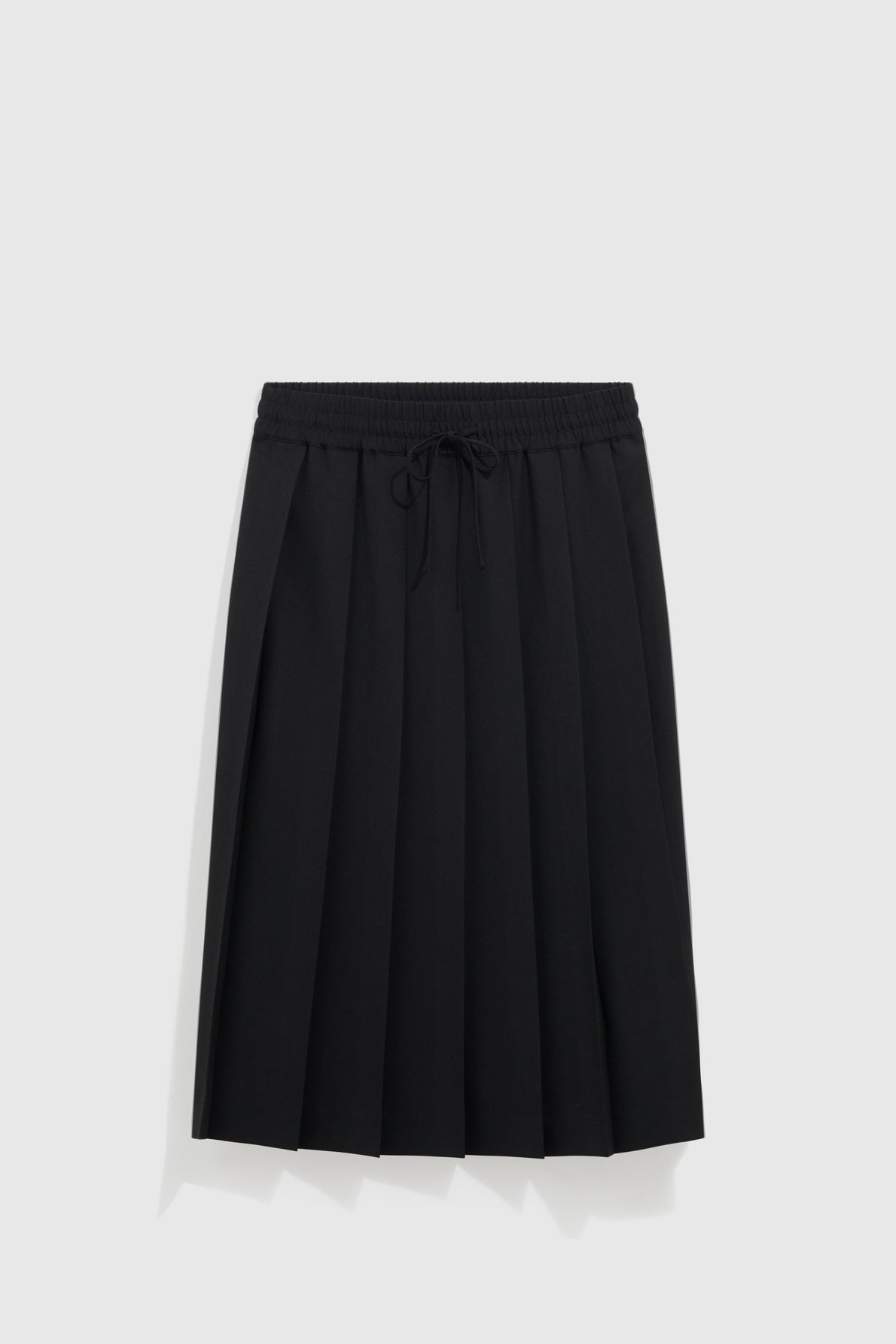 A chic à la française jupe plissée noire with an elastic waistband and drawstring, this elegant jupe mi-longue is displayed against a plain light gray background.