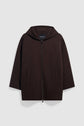 Dark brown manteau à capuche with a front zipper, two front pockets, and wide sleeves in laine double face, displayed on a plain light background.