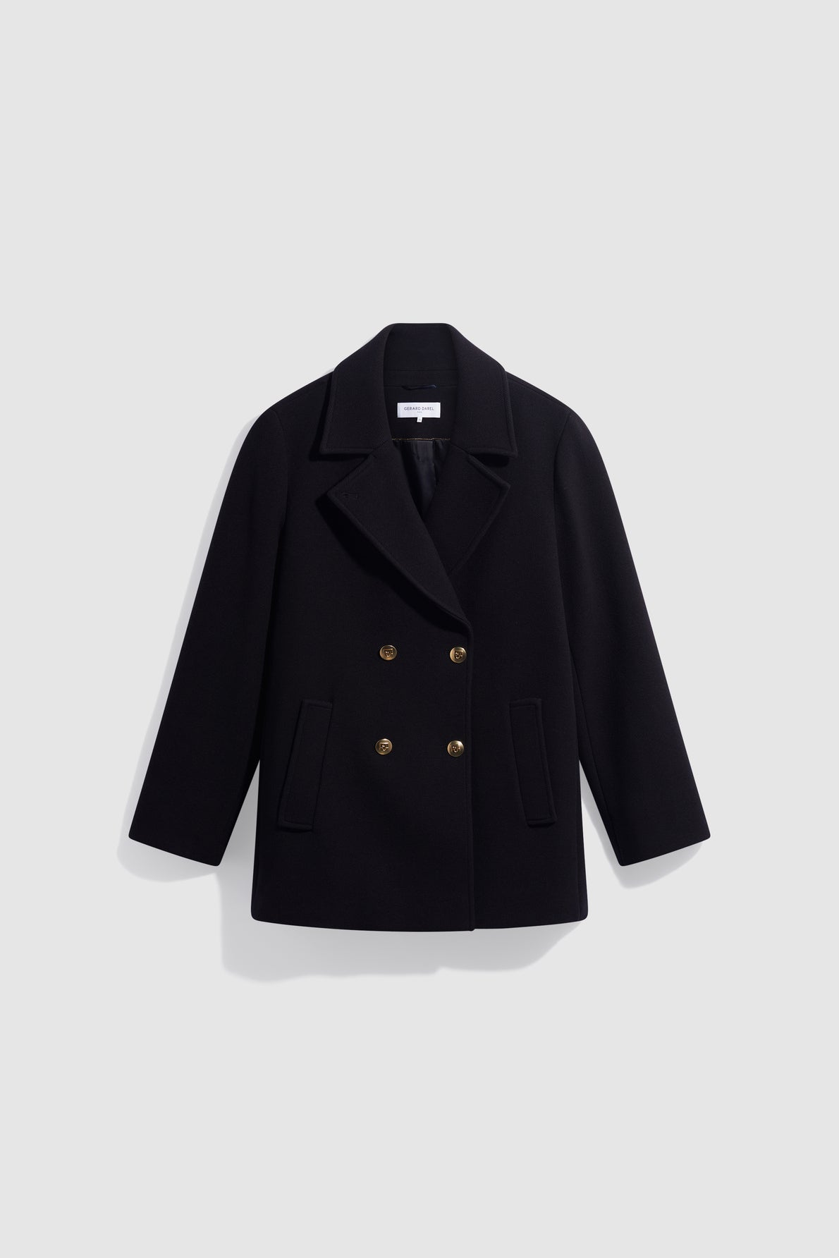 Black double-breasted peacoat crafted from fine laine vierge, featuring gold buttons, two front pockets, and a wide collar, displayed on a plain light gray background.
