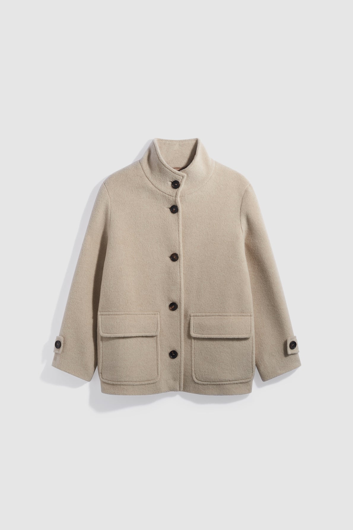Beige wool jacket with a stand collar, large front buttons, two front flap pockets, and buttoned cuffs, displayed on a white background—this manteau laine alpaga écru embodies timeless elegance in a chic manteau court silhouette.