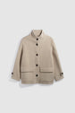 Beige wool jacket with a stand collar, large front buttons, two front flap pockets, and buttoned cuffs, displayed on a white background—this manteau laine alpaga écru embodies timeless elegance in a chic manteau court silhouette.