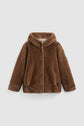 A brown manteau court en fausse fourrure avec capuche, doté de manches longues, d’une fermeture frontale et de deux poches latérales, présenté sur un fond blanc uni.