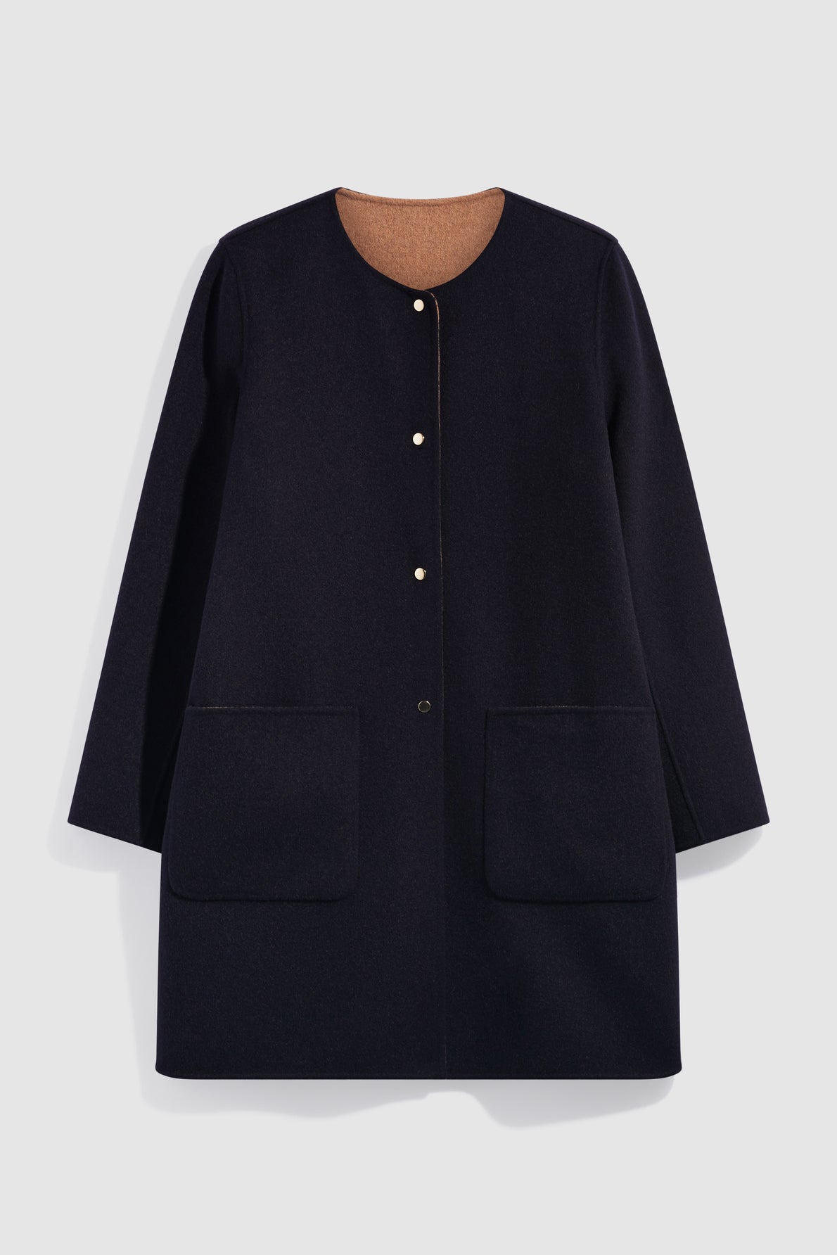 A long-sleeve, knee-length, dark navy manteau en laine with a round neckline, two large front pockets, and a hidden snap button closure. The inside lining is light brown.