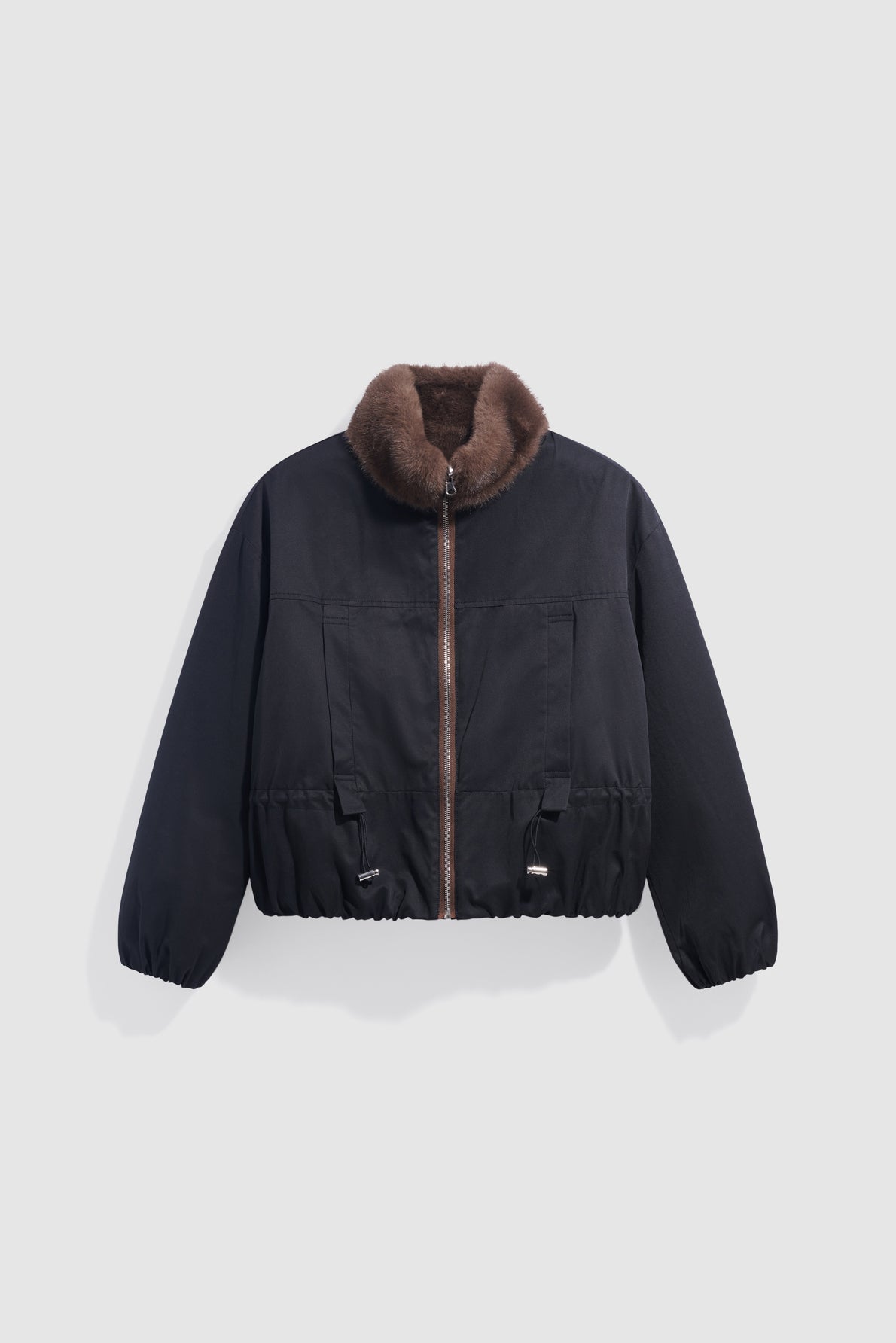 A black bomber jacket with a brown faux fur collar, front zipper, elastic cuffs, and adjustable waist, this parka courte is displayed on a plain light gray background.