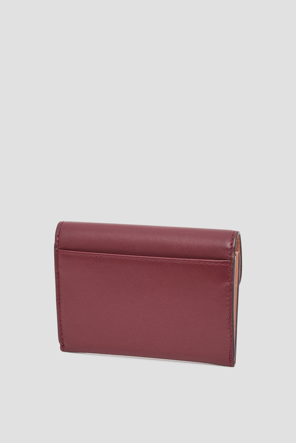 A closed maroon leather petit portefeuille cuir, shown from the back against a plain light gray background.