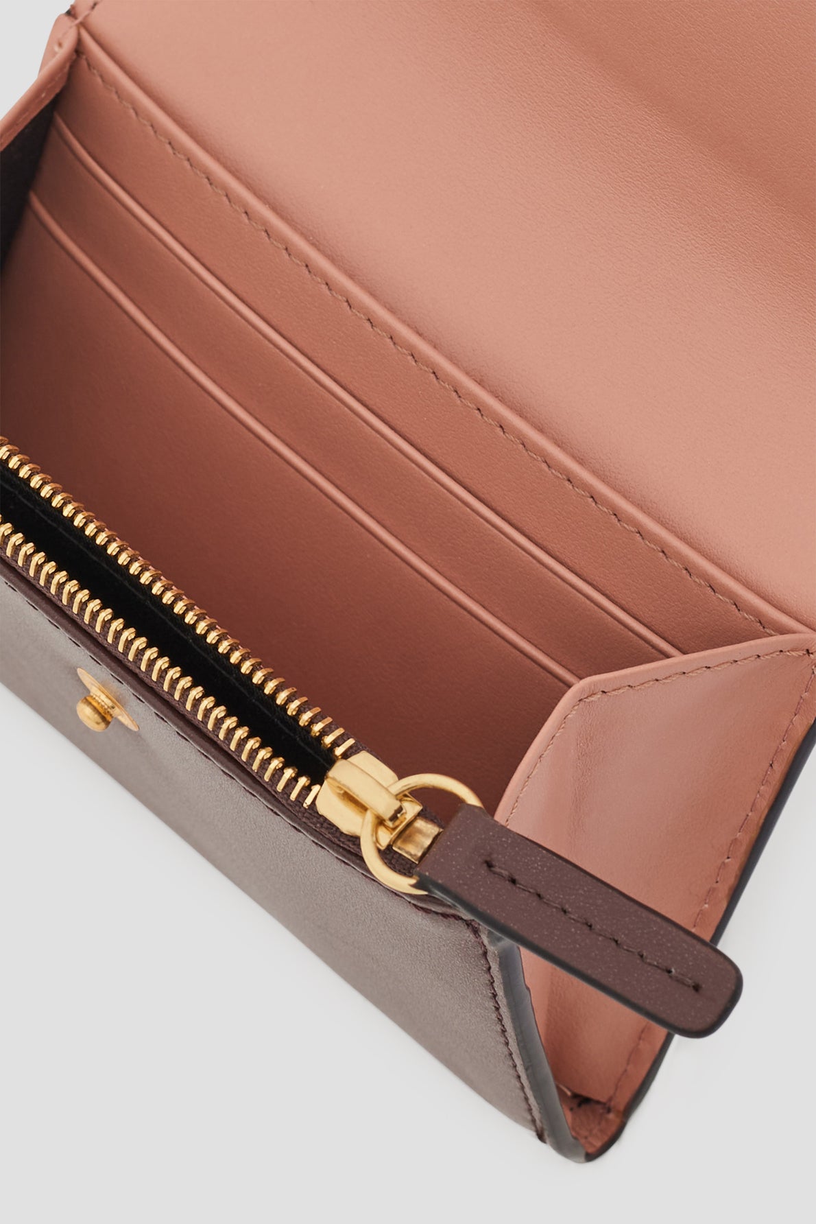 Open pink and brown leather wallet with gold zipper, card slots, and a pocket inside. This portefeuille super plat features a visible wallet lining and zipper pull, offering both elegance and practicality for everyday use.