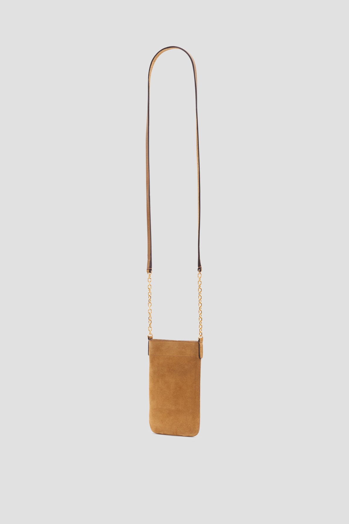 A small tan cuir velours shoulder bag with a long thin leather strap and elegant bandoulière chaîne gold chain accents, designed as a chic porte-téléphone, displayed on a plain light grey background.