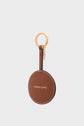 Round brown leather keychain with white stitching, featuring GERARD DAREL in gold letters, attached to a gold keyring with a small gold charm—radiating the élégance parisienne and allure charm of Gerard Darel—on a light gray background.