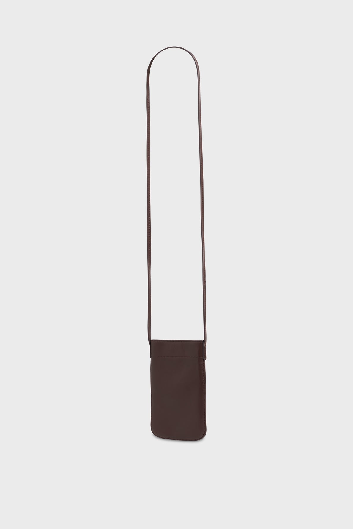 A small, rectangular, dark brown leather crossbody bag crafted from cuir de vachette with a long, thin strap, perfect as an accessoire tendance to complement any outfit. Displayed against a plain white background.