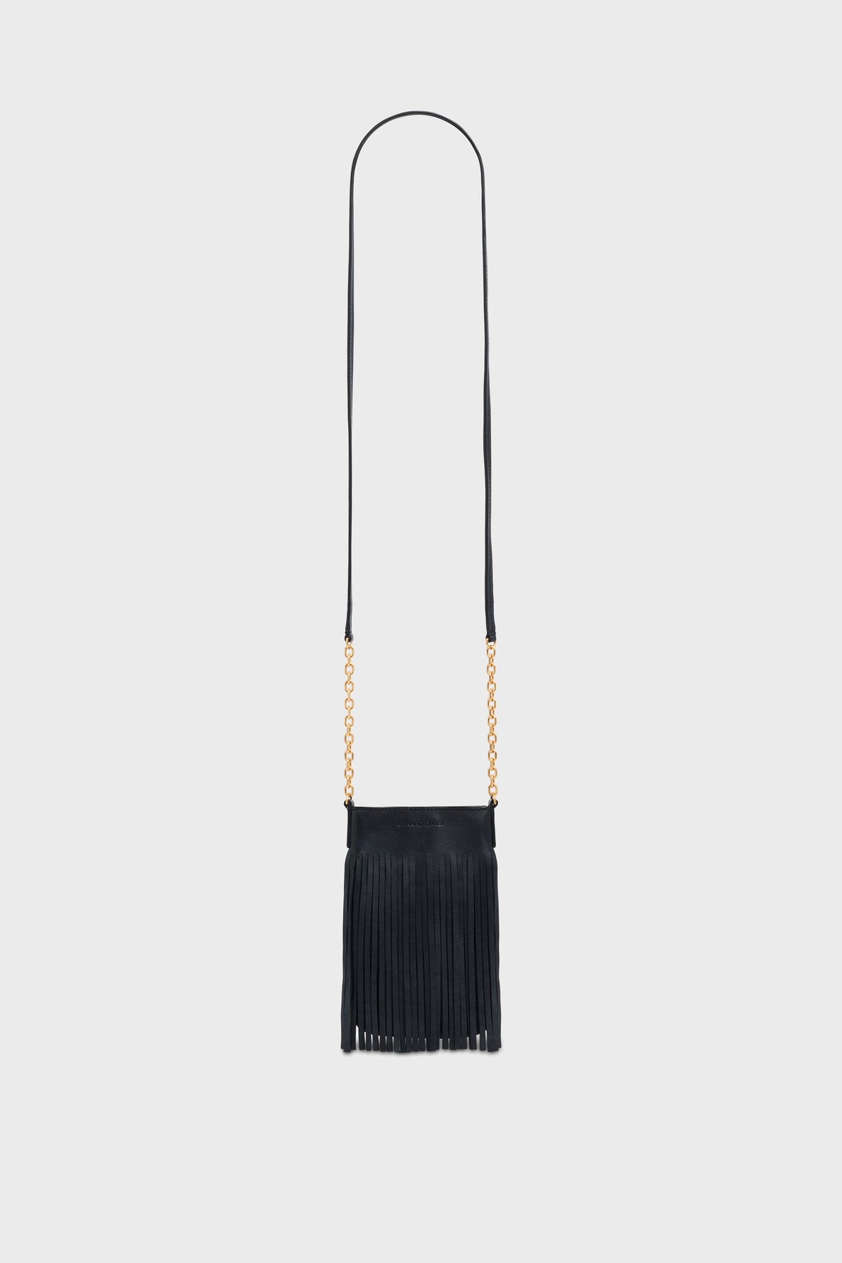 A small black fringe bag crafted from cuir de qualité, featuring a long, thin bandoulière chaîne and gold chain accents on the sides, photographed against a plain light gray background.