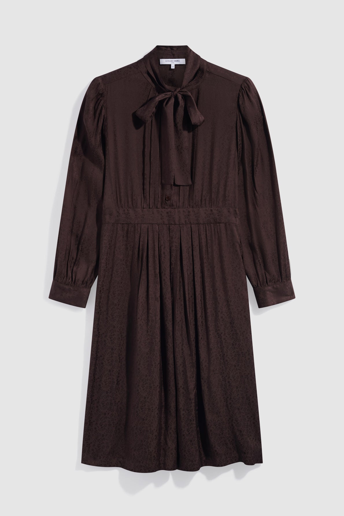 A long-sleeved, dark brown midi dress with a subtle motif floral pattern, button-down front, gathered waist, and a bow tie at the collar, displayed on a plain light background.