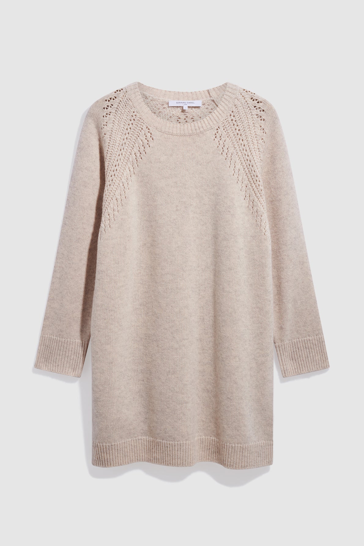 A beige, long-sleeve knit sweater with ribbed cuffs and hem, and decorative openwork knit patterns on the shoulders and upper chest, perfect for layering over a robe courte or pairing with your favorite jeans on cooler days.