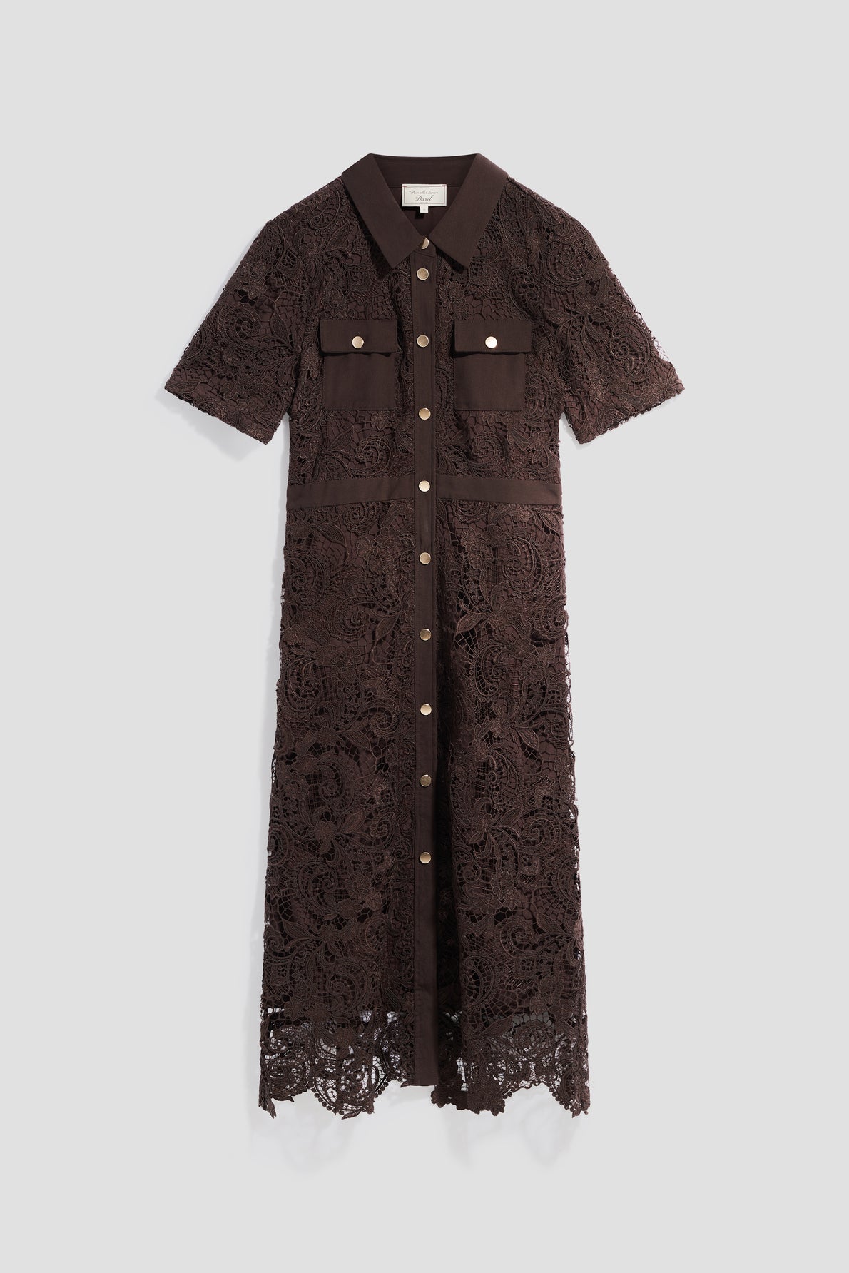 A brown robe midi en dentelle with short sleeves, front buttons, chest pockets, and a collared neckline is displayed against a plain light background. This robe cintrée combines elegant lace detailing with a flattering silhouette for timeless sophistication.