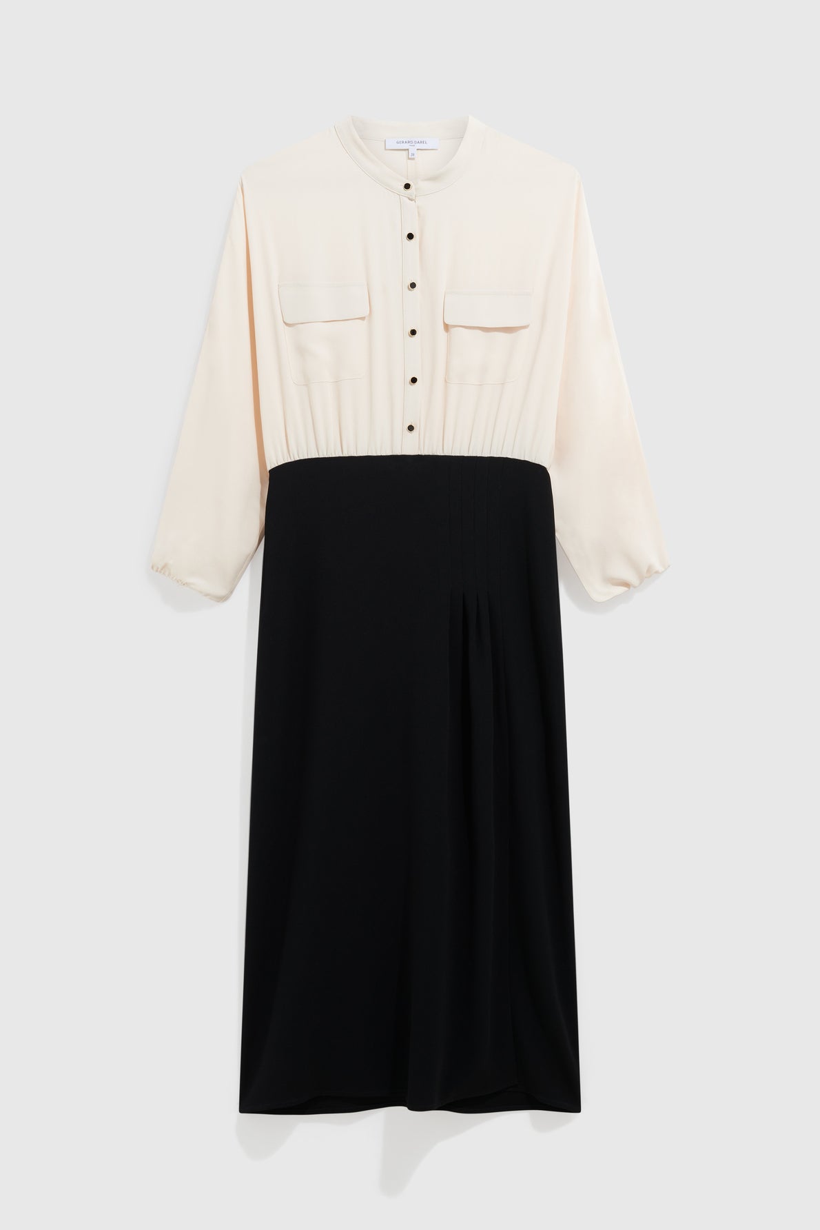 Long-sleeve robe bicolore midi featuring a cream button-up top with chest pockets and a high-waisted black skirt, displayed against a plain light background for an élégante silhouette.