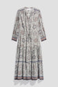Long-sleeve, ankle-length robe longue with an imprimé floral and geometric pattern, featuring a tie at the neckline and tiered skirt. The dress has a white base with blue, brown, and purple accents on the cuffs and hem.
