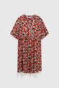 Short-sleeved, knee-length robe courte with a red, black, and white floral print, V-neckline, and front button detailing; this robe fleurie features a flattering taille empire silhouette and is displayed against a plain white background.