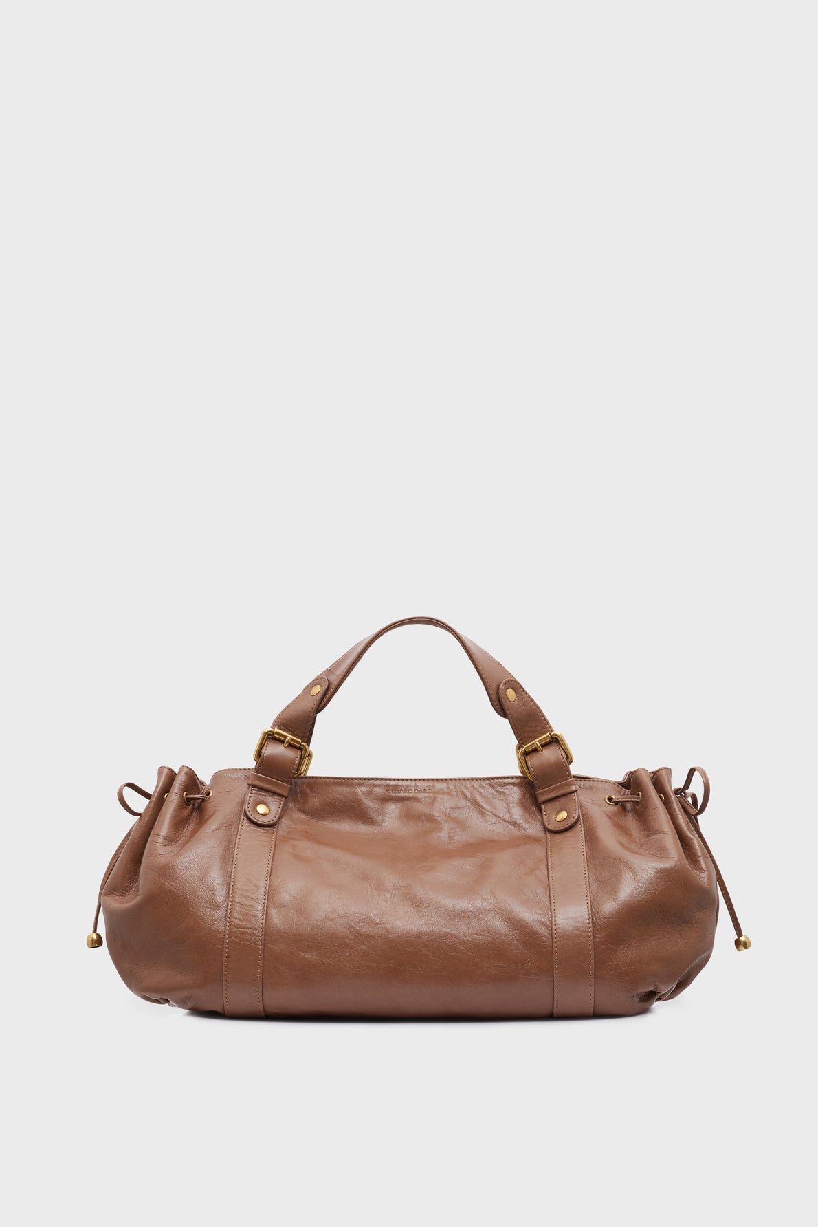 A chic brown cuir froissé leather sac à main with two handles, elegant gold hardware, and drawstring details on each side, set against a plain white background.