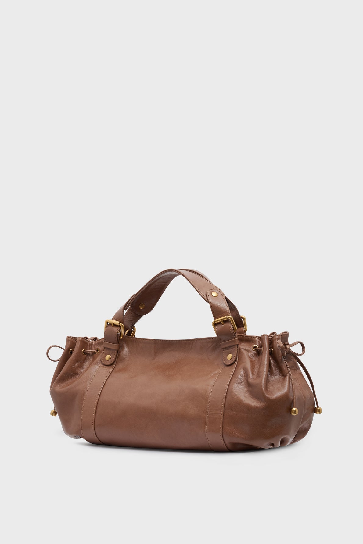 Brown cuir froissé sac à main with gold hardware, double handles, and decorative side drawstrings, inspired by the iconic sac 24H silhouette, shown on a plain white background.