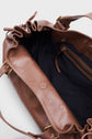 Brown leather sac à main with a ruffled top edge, gold hardware, and visible black interior lining. Crafted from cuir froissé for added texture, this spacious sac 24H features an inner zippered pocket and a versatile shoulder strap. The bag is open, highlighting its roomy interior.
