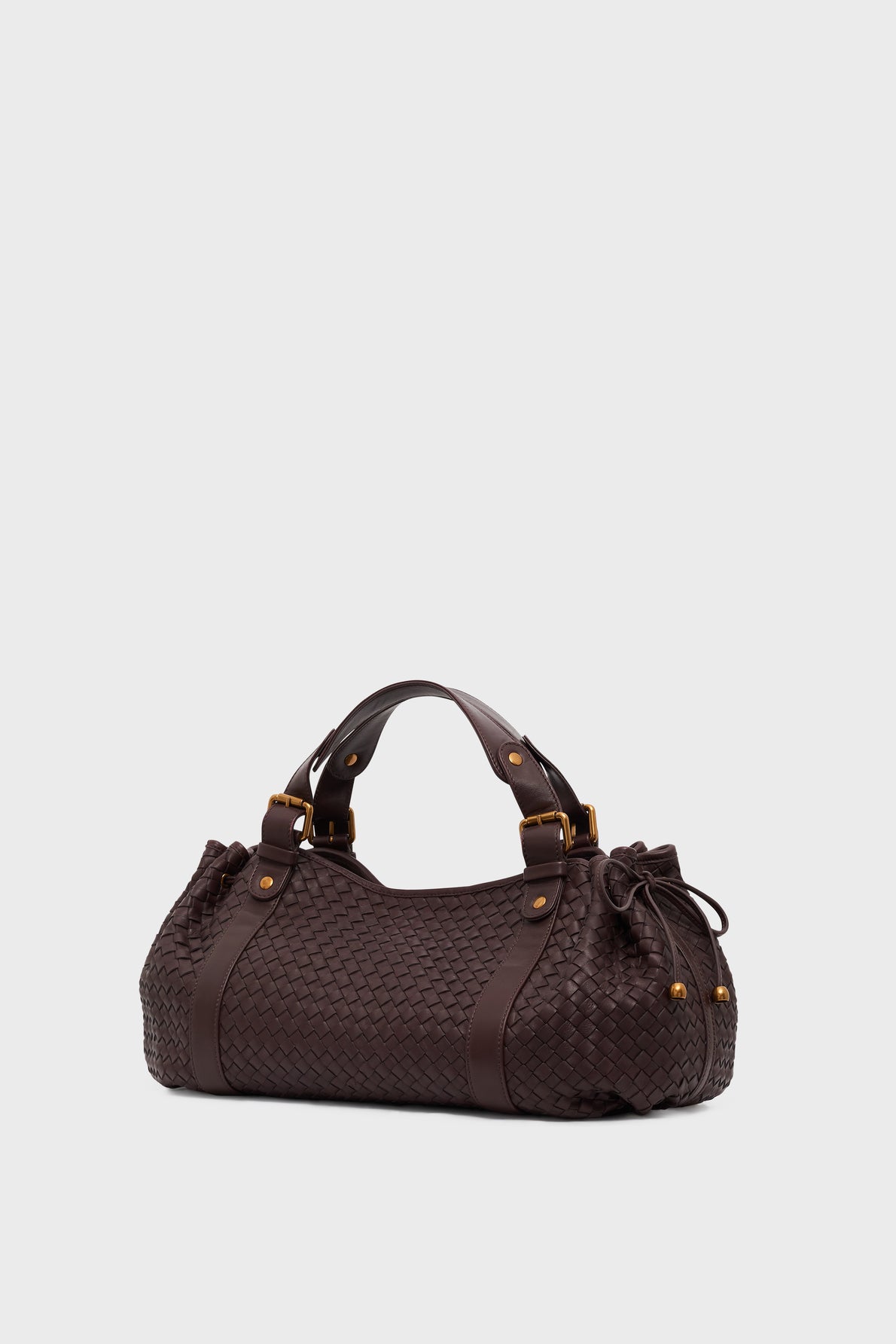 A dark brown sac à main in cuir d’agneau tressé with two handles, gold hardware, and leather straps, displayed on a light gray background. Perfect for any occasion with its 24H style elegance and versatility.