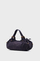 A dark blue, cylindrical suede sac à main with two handles and gold-tone hardware, set against a plain light gray background.