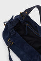 A close-up of an open dark blue sac à main en cuir velours with a black interior, gold hardware, and a zippered inner pocket.