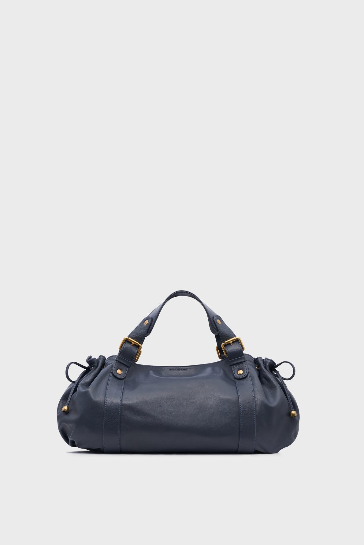 A navy blue sac à main cuir with gold hardware, short handles, and gathered side details, displayed against a plain white background—a refined piece of maroquinerie Darel.