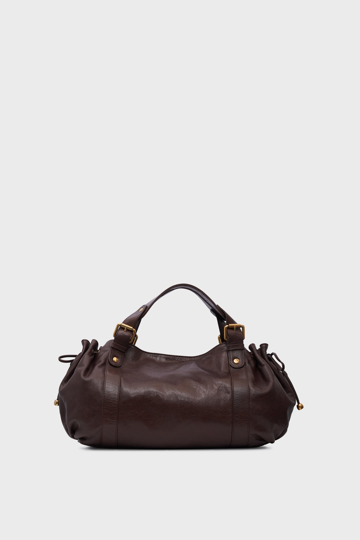Dark brown leather Vanessa Bruno sac à main cuir with two short handles, gold hardware, and drawstring details on both sides, displayed against a plain light gray background.
