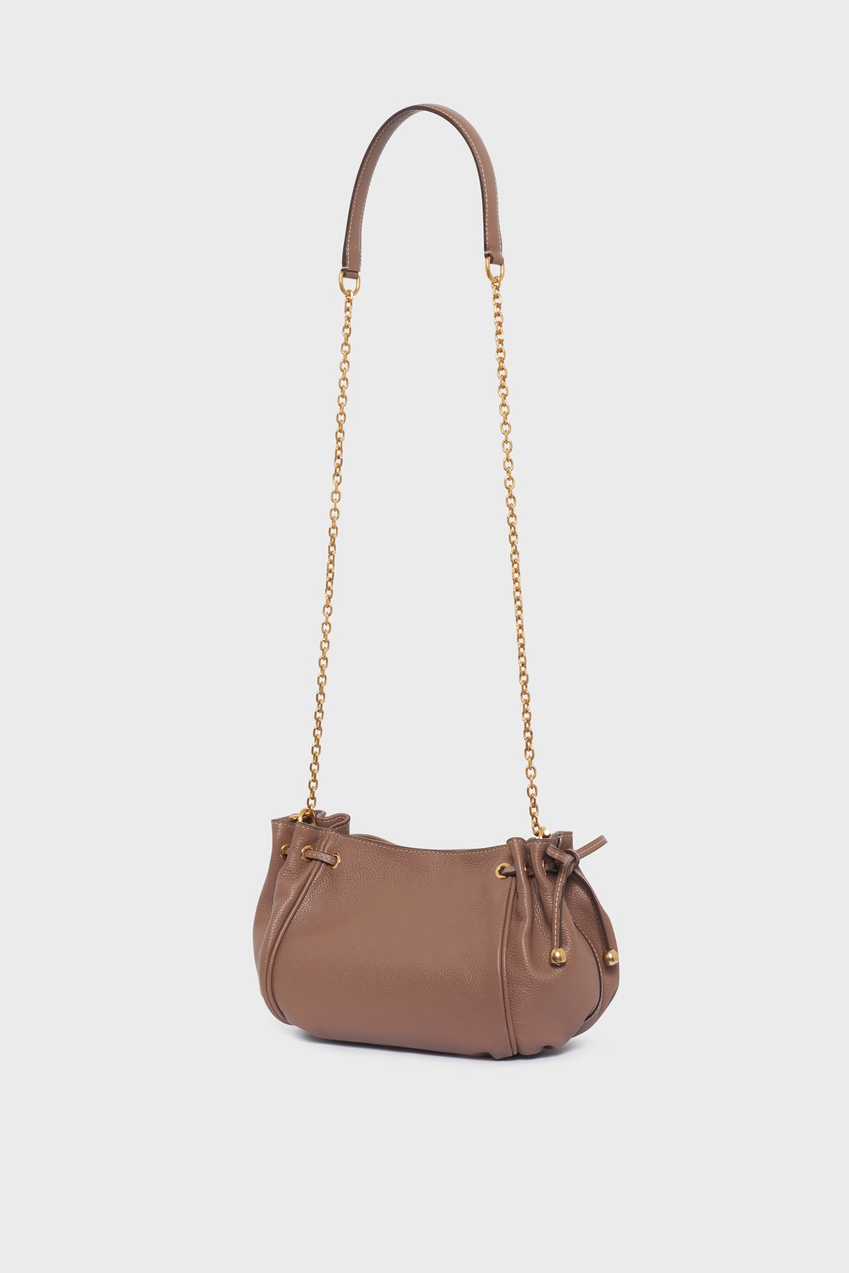 Brown leather handbag with a gold chain strap and drawstring closure, crafted in cuir grainé for added texture and durability, shown against a plain white background. This elegant sac bandoulière reflects the timeless style of Gerard Darel.