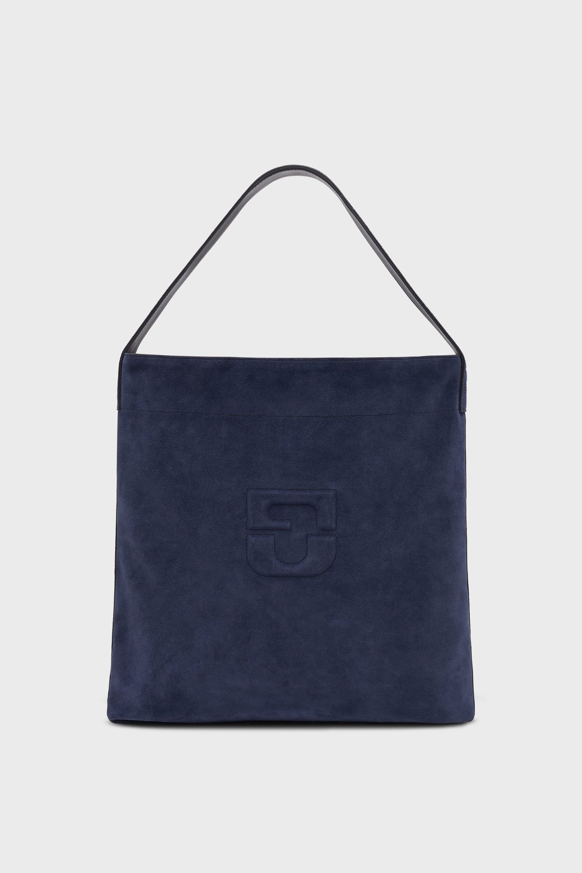 A navy blue cuir velours totebag with a single black strap and an embossed geometric logo on the front, photographed against a plain light gray background.