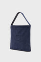 A navy blue cuir velours sac hobo with a single wide shoulder strap and an embossed geometric logo on the front, set against a plain light background.