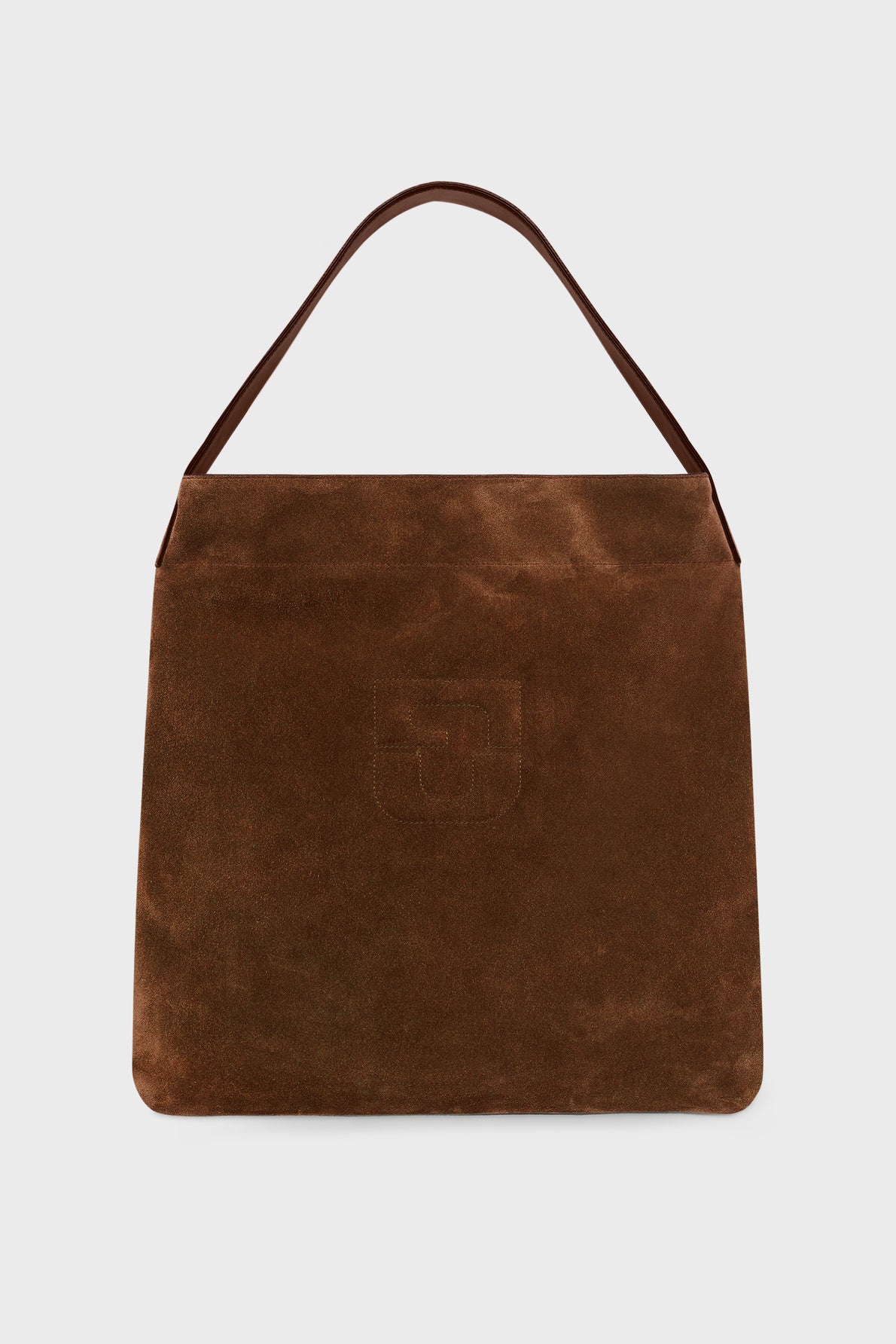 Brown suede handbag with a single top handle and an embossed logo on the front, crafted from luxurious cuir velours and photographed against a plain white background. The bag has a minimalist, rectangular design reminiscent of a refined totebag.
