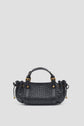 A black sac à main tressé in luxurious cuir d’agneau, featuring gold hardware, two short handles, and side drawstring details, set against a plain light gray background.