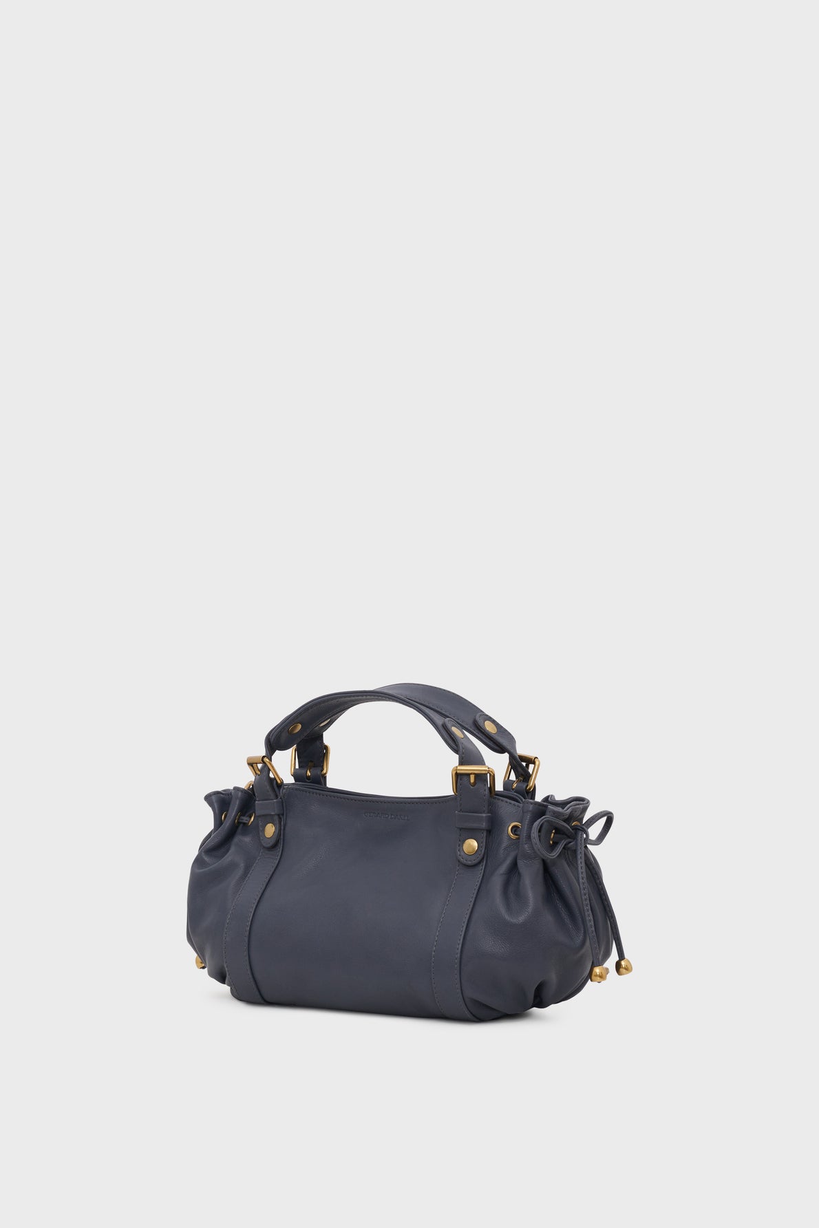 A navy blue cuir sac à main with gold hardware, short double handles, a bandoulière amovible, and gathered side details, shown against a plain light gray background.