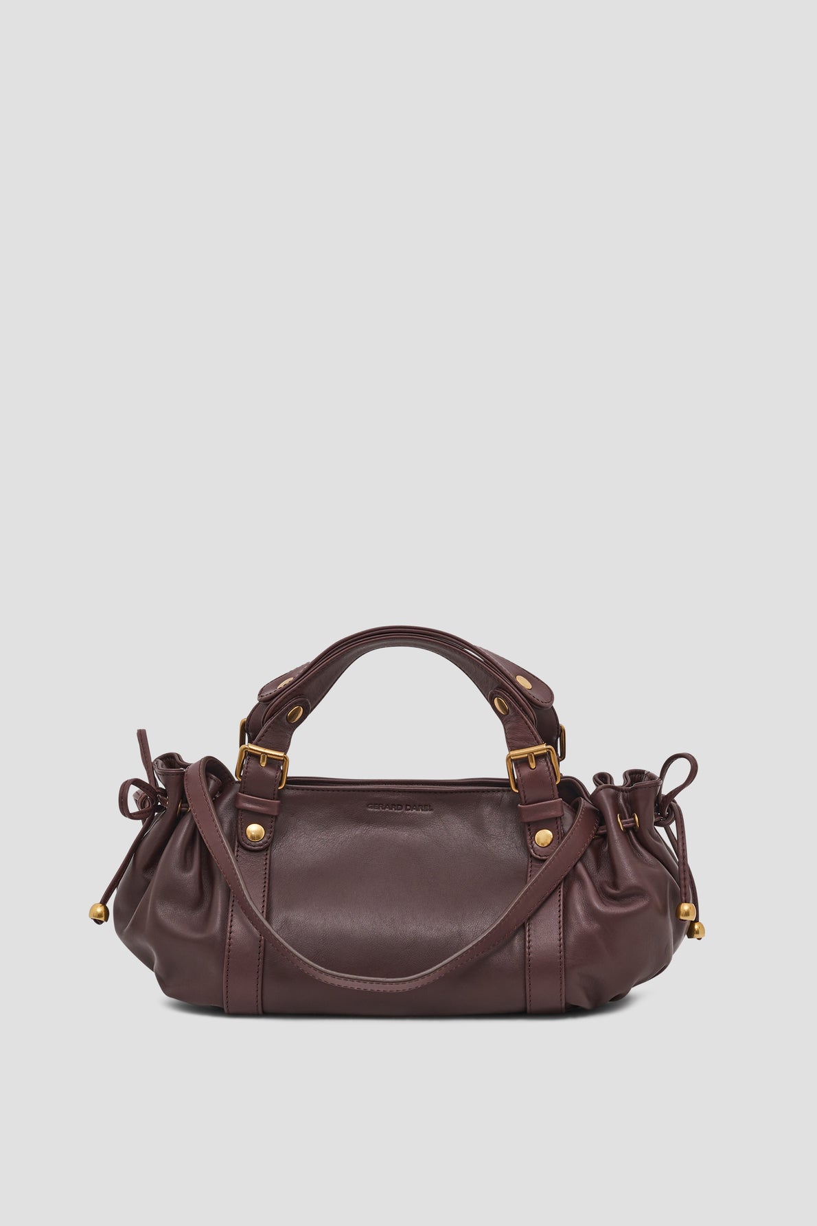 A dark brown leather sac à main with gold hardware, double handles, and gathered side details, displayed against a plain white background.