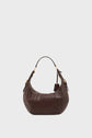 A dark brown cuir de vachette hobo handbag with a single short handle and gold hardware, displayed on a plain white background, perfectly embodies l’élégance parisienne.