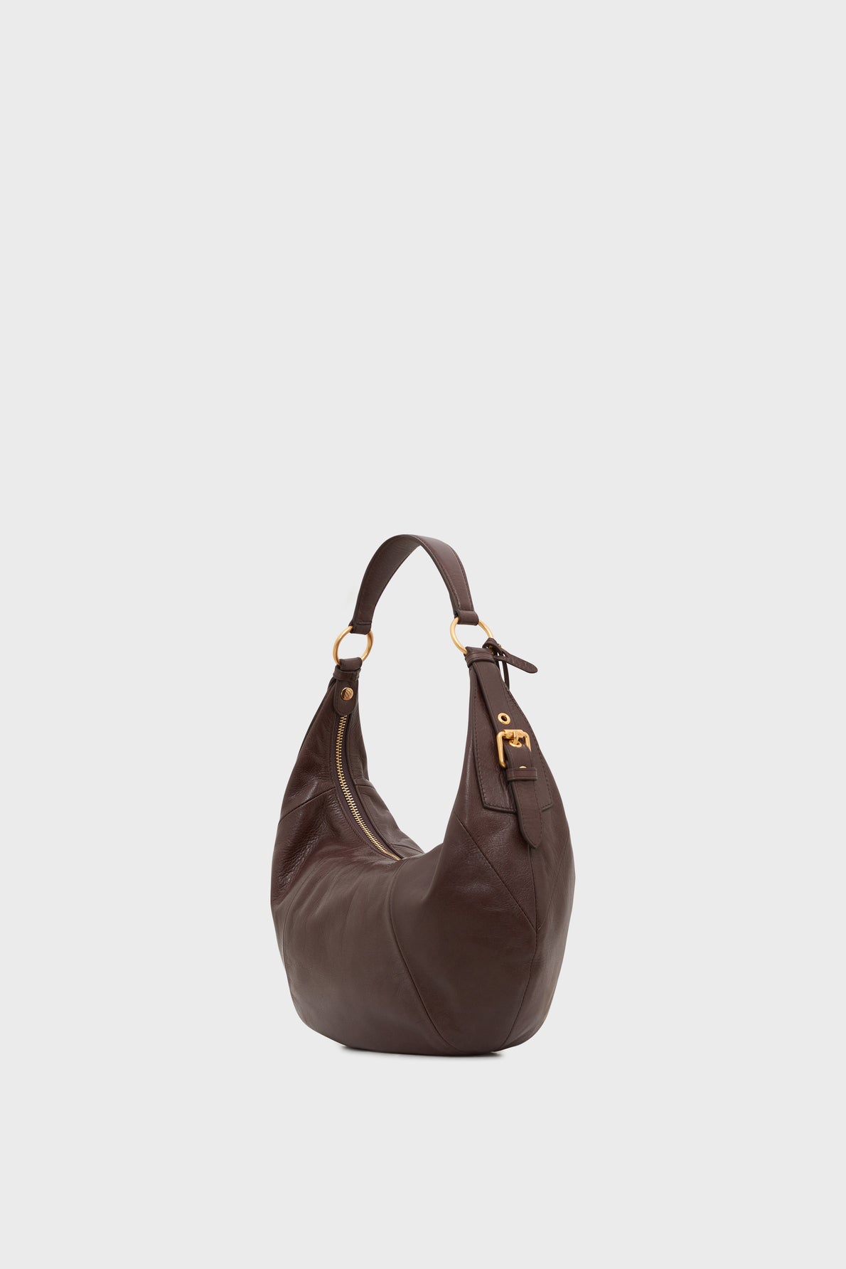 A dark brown sac hobo in cuir de vachette with a single curved handle and gold hardware, radiating élégance parisienne, shown on a plain white background.