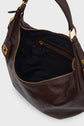A dark brown cuir de vachette leather sac hobo with gold-tone hardware, shown from above. The bag is unzipped, revealing a black fabric interior and an inner zippered pocket—an effortless expression of élégance parisienne.